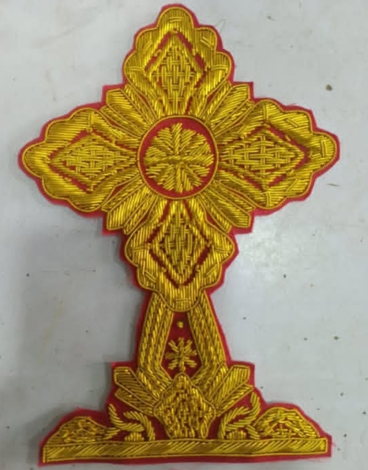 Golden embroidered cross badge with red edging for ceremonial vestments, uniforms, or display