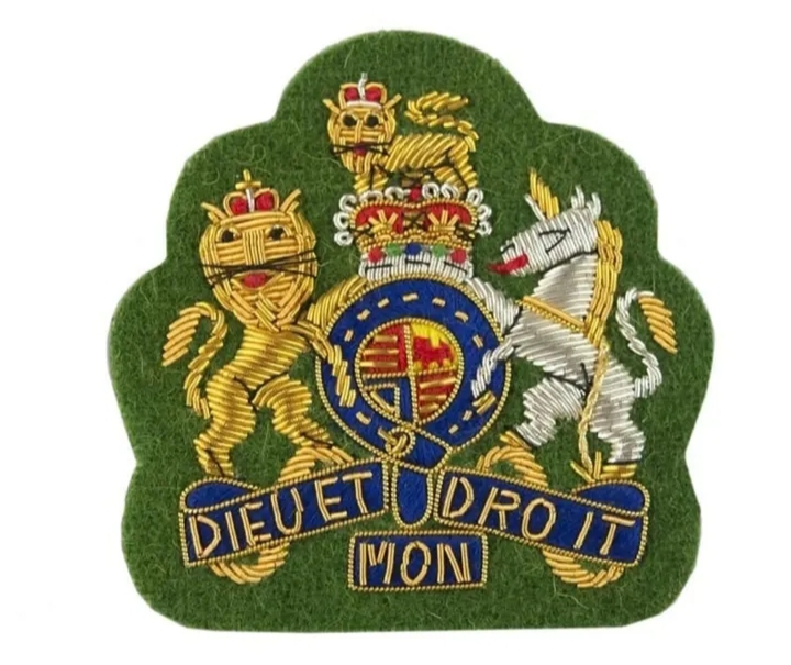 Royal Coat of Arms embroidered badge with lion and unicorn on green felt background.
