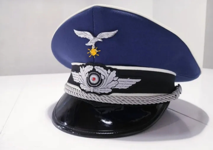 Blue Air Force-style peaked cap with silver embroidery, eagle insignia, and black glossy visor.