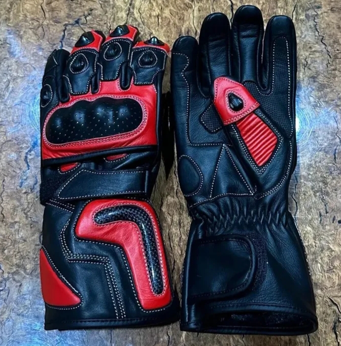 Black and red motorcycle gloves with carbon fiber protection and reinforced padding for riders.